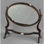 A swing frame mirror, of oval form,