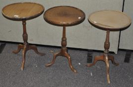A pair of occasional tables and another, all of circular form on tripod bases,