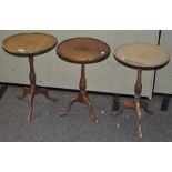 A pair of occasional tables and another, all of circular form on tripod bases,