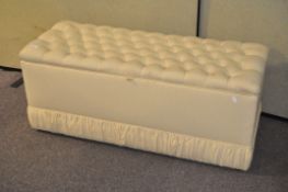 A vintage ottoman, upholstered in yellow fabric,
