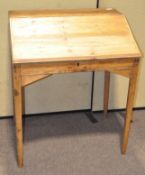 A vintage pine clerk's desk, the opening front revealing storage inside,