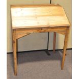 A vintage pine clerk's desk, the opening front revealing storage inside,