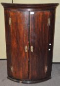 A 19th century mahogany corner cabinet, the doors opening to reveal four sections,
