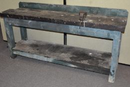 A large wooden work bench, with attached vice,