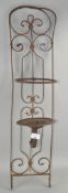 An ornate metal candle holder for wall mounting,