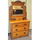 A 20th century oak dressing table with swing mirror to top, three long drawers to base,