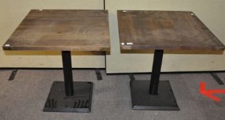 A pair of pub tables, raised on metal bases,