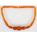 A large graduated orange bead necklace, strung plain with no clasp.