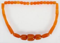 A large graduated orange bead necklace, strung plain with no clasp.