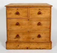 A Victorian pine chest of two short and two long drawers with turned pulls and plinth base,