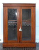 A Victorian mahogany pier cabinet, with a pair of glazed doors, on a plinth base,