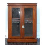 A Victorian mahogany pier cabinet, with a pair of glazed doors, on a plinth base,