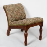A late 19th century upholstered oak gout stool, with ring turned fore legs,