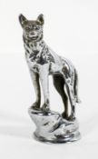 A chrome car mascot in the form of a wolf on a rocky outcrop, stamped copyright,