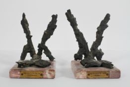 A pair of Coventry Blitz bookends, formed from shrapnel on pink marble bases,