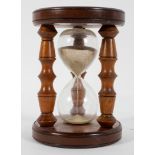 A turned wood sand timer, probably 20th century, with three turned supports,