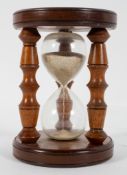 A turned wood sand timer, probably 20th century, with three turned supports,