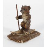 A novelty lead cold painted figure of a skiing bear holding a skiing pole in one hand,