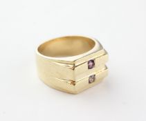 A yellow metal signet ring set with a purple and pale blue cubic zirconia.