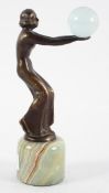 An Art Deco style bronze figure of a dancer holding a glass ball, on a green marble base,