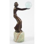 An Art Deco style bronze figure of a dancer holding a glass ball, on a green marble base,