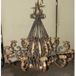 A wrought iron twelve light chandelier, with scrolling branches and gilt foliate decoration,