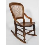 A beech and elm rocking chair, with caned back and seat, on turned front legs with box stretchers,