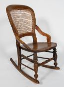 A beech and elm rocking chair, with caned back and seat, on turned front legs with box stretchers,