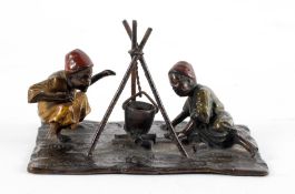 A Bergmann style bronze group of two Arab boys by a fire,