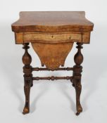 A Victorian fold-out games and work table, of serpentine form, with scrolling inlay,