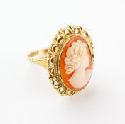 A yellow metal ring set with an oval carved cameo with abstract design mount.