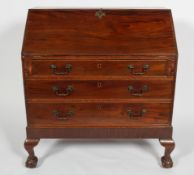 A George III mahogany bureau with a fitted interior above three graduated drawers and claw on ball