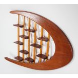 A 1960's vintage teak wood bespoke made wall shelving display, having a boomerang shape,