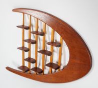 A 1960's vintage teak wood bespoke made wall shelving display, having a boomerang shape,