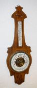 An aneroid barometer, by George Perry & Co, Bournemouth, on an Arts and Crafts style walnut mount,