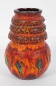 A 1960's West German pottery vase, with bulbous base and ribbed tapering neck, in a fat lava glaze,