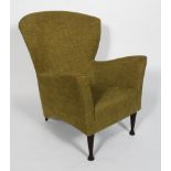 A 1950's style arm chair, the broad back above slightly flaring arms and stuffed over seat,