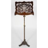 A Victorian fret work music stand, on a telescopic brass and iron base,