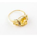 A yellow metal ring set with three citrine quartz and interspaced with a trio of diamonds.
