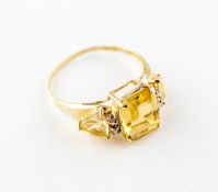 A yellow metal ring set with three citrine quartz and interspaced with a trio of diamonds.