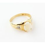 A yellow metal ring principally set with a commercial quality white opal