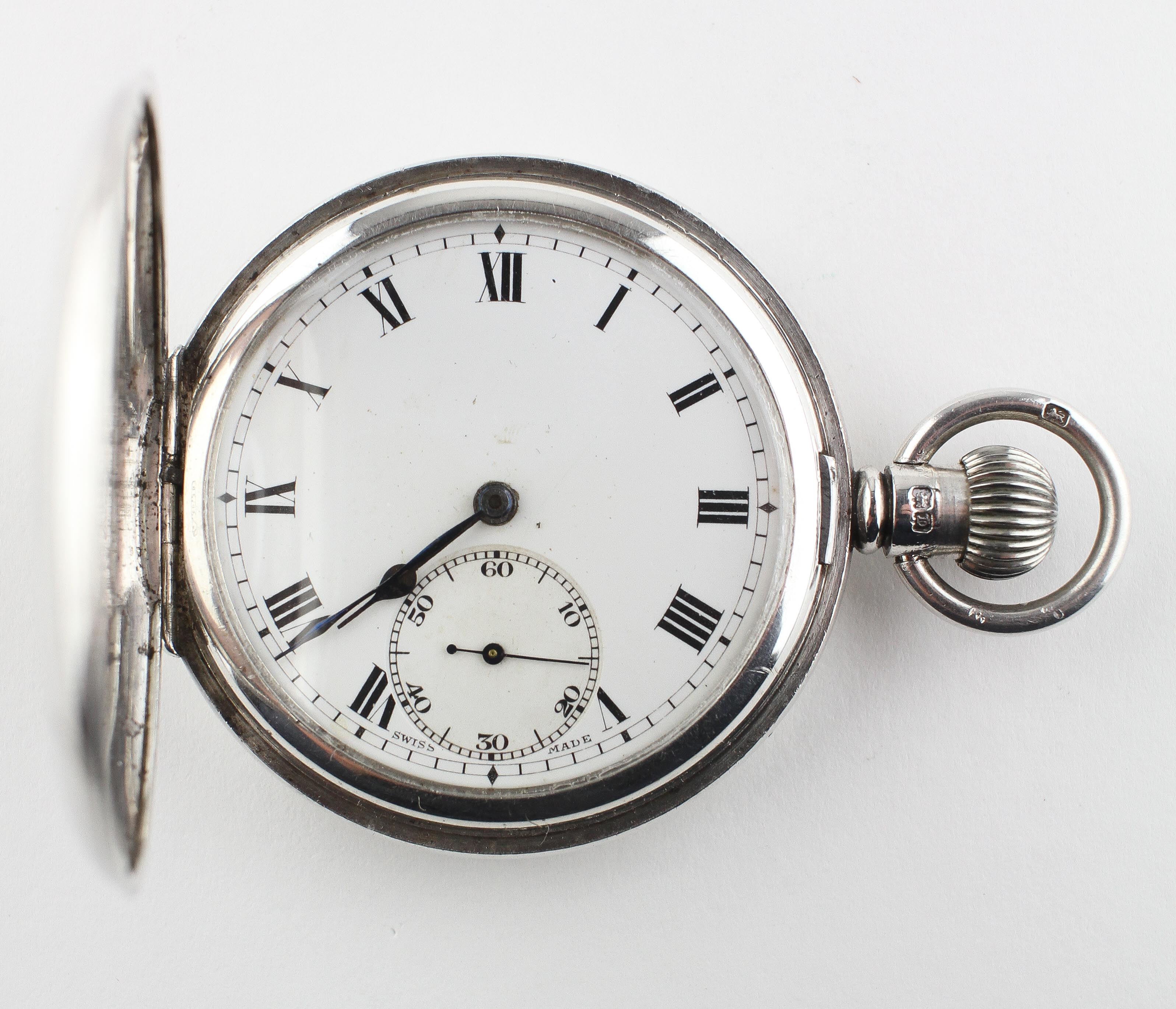 A half hunter pocket watch. Circular white dial with roman numerals.