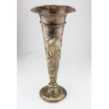 An early 20th century Aesthetic movement silver trumpet vase with highly embossed floral decoration