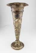 An early 20th century Aesthetic movement silver trumpet vase with highly embossed floral decoration