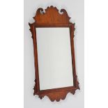 A George II style walnut fret work mirror, the rectangular plate inside a scrolling frame,