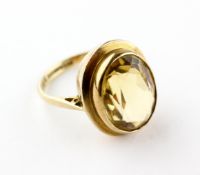 A yellow metal single stone ring set with an oval faceted cut citrine quartz