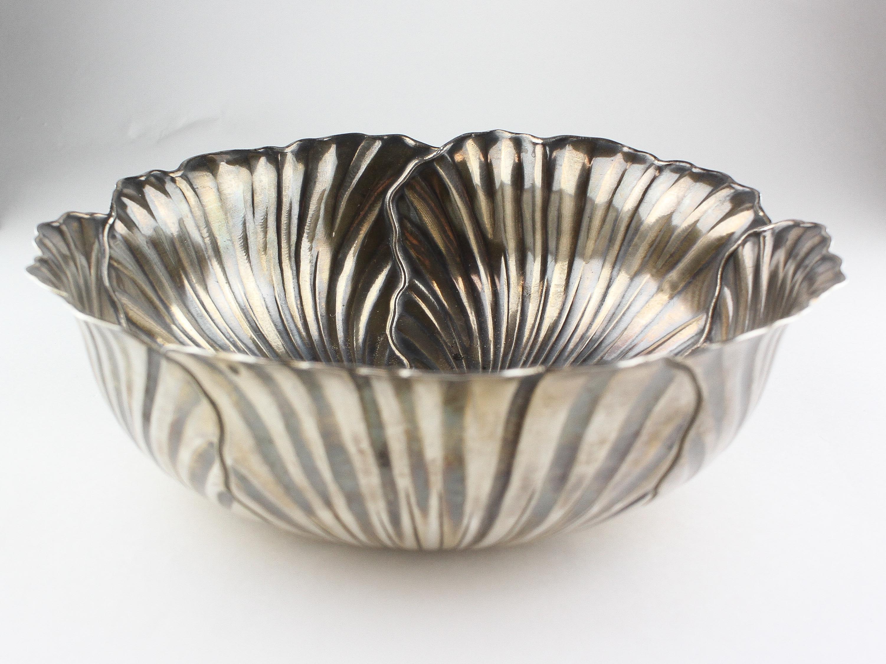 A large Middle Eastern white metal bowl in the form of a water lily, indistinctly marked,