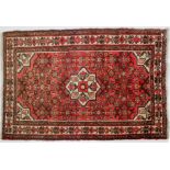 A Hamadan rug, a central star motif on abrashed pink ground 160cm x 110cm; and a Balouch Prayer rug,
