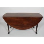 A Georgian mahogany oval drop leaf dining table, with tapering legs on pad feet,