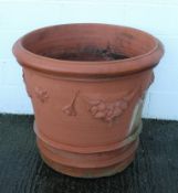 A large terracotta planter, or tapering cylindrical form, with swags and masks in relief,